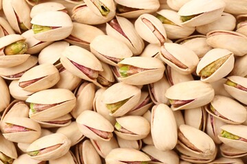 Tasty unpeeled pistachios as background, top view