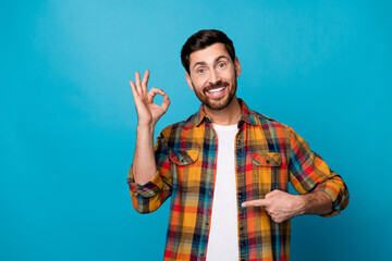 Photo portrait of handsome young male show okey symbol point stomach wear trendy plaid outfit...
