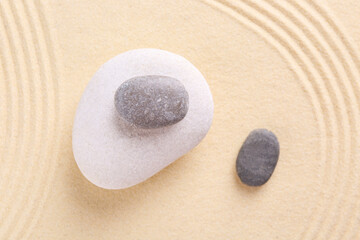 Fototapeta na wymiar Zen garden stones on sand with pattern, flat lay
