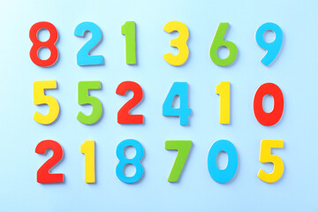 Colorful numbers on light blue background, flat lay