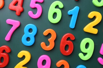 Colorful numbers on green background, flat lay