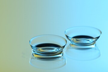 Pair of contact lenses on mirror surface, closeup
