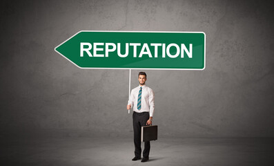 Young business person in casual holding road sign