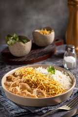 Chicken stroganoff with rice and straw potatoes. Strogonoff.