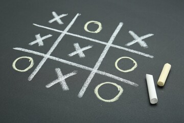 Tic tac toe game drawn on chalkboard