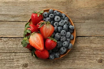 Fotobehang Fresh strawberries and blueberries on old wooden table, top view © New Africa