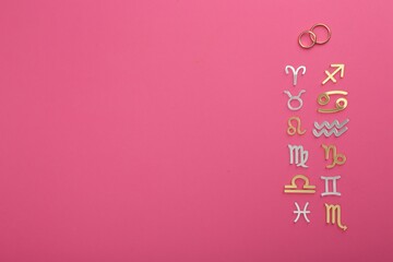 Zodiac compatibility. Signs with wedding rings on pink background, flat lay. Space for text