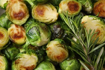 Obraz premium Delicious roasted Brussels sprouts and rosemary as background, top view