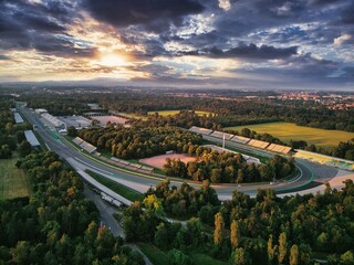 Drone shot of F1 race circuit track surrounded by greenery during sunset in Monza, Italy