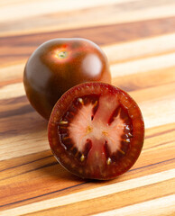 A Sweet Juciy Brown Kumato Tomato on a Wooden Cutting Board