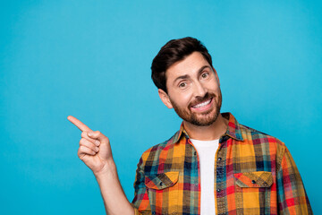 Photo of good mood pleasant man with beard dressed plaid shirt indicating at discount empty space...