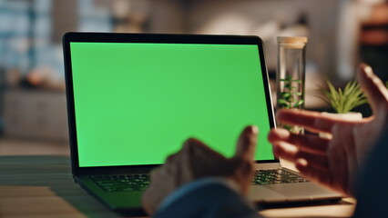 Director hands videocalling chromakey computer at evening desk workplace closeup