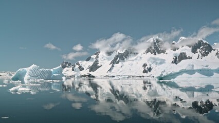 Glacial mountains and icebergs reflection on ocean bay aerial. World warming ecology problem of environment. Global climate change with melting ice lands. Amazing Antarctica seascape at South Pole © mozgova