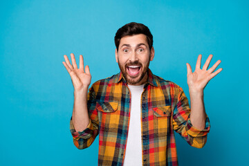 Portrait of overjoyed funny eccentric guy with stubble wear plaid shirt raising palms up scream...