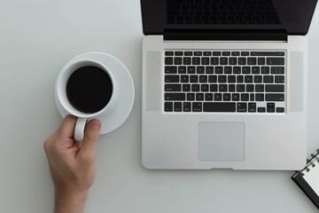 Top view of laptop with black keyboard on white table, hand holding coffee cup near it, notebook next to the macbook pro, grey background - Powered by Adobe