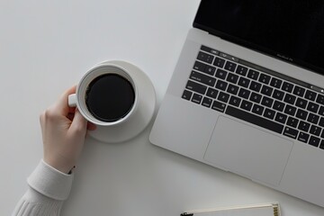 Top view of laptop with black keyboard on white table, hand holding coffee cup near it, notebook next to the macbook pro, grey background, - obrazy, fototapety, plakaty