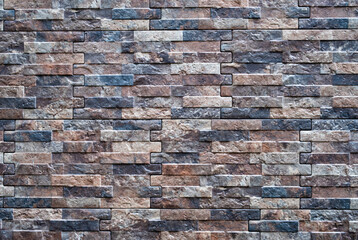 Decorative tiles under the brick on the facade of the house. Abstract brown brick wall background	