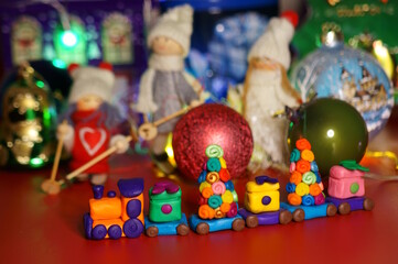 Naklejka premium A toy train with Christmas decorations on the background of the scenery. A Christmas tale.