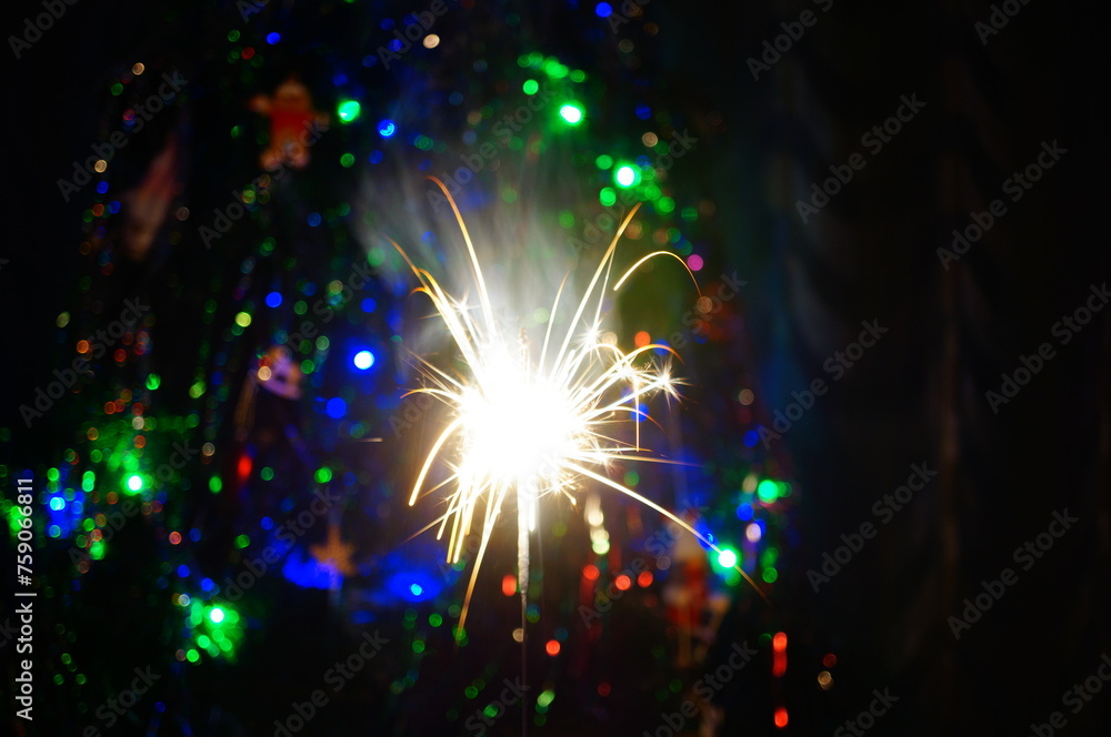 Wall mural sparkling sparklers at night. bright christmas background. a festive event.