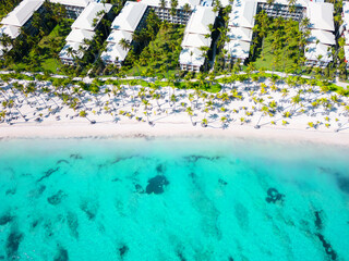 Fototapeta na wymiar Aerial top view tropical hotel beach with white sand and palm trees. Turquoise water of the Caribbean sea. Best place for summer vacations