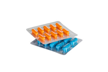 Blue and orange capsules or pills in blister isolated on white background.