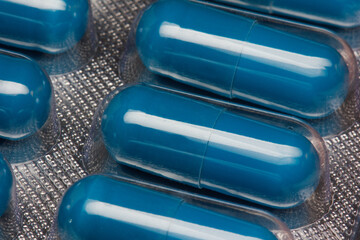 Blue capsules or pills in blister close up. - obrazy, fototapety, plakaty