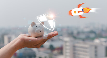 Piggy bank on hand provides a shield to protect assets and save from larceny rocket attacks in...