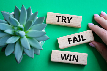Try Fail Win symbol. Concept words Try Fail Win on wooden blocks. Beautiful green background with...