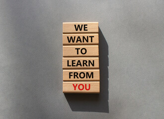 We want to learn from you symbol. Wooden blocks with words We want to learn from you. Beautiful grey background. Business and We want to learn from you. Copy space.