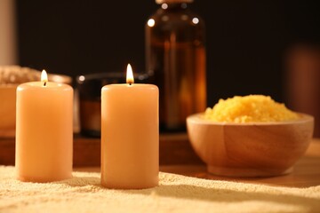 Spa composition with burning candles and personal care products on soft light surface, closeup