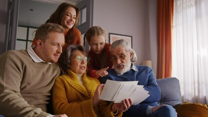 Senior woman sharing pictures with big family members