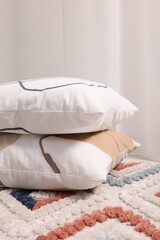 Fototapeta na wymiar Stacked soft pillows on floor in room