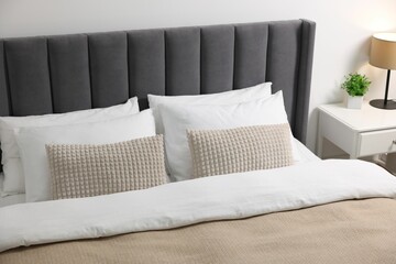 Soft pillows and duvet on bed at home