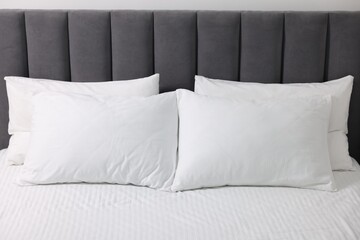 Soft white pillows and bedsheet on bed
