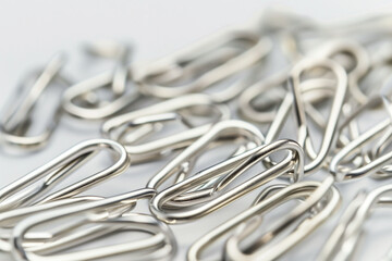 close-up of neatly arranged paper clips, symbolizing organization and efficiency in the workplace, against a crisp white background,