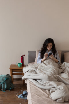girl lying in bed with a phone