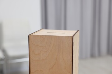 Wooden ballot box on blurred background, closeup