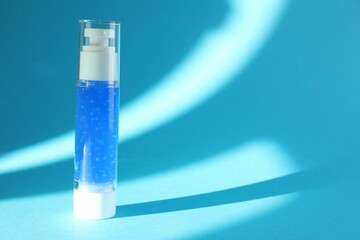 Bottle of cosmetic product on light blue background. Space for text