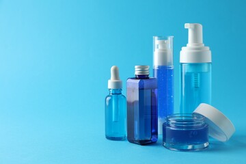Set of luxury cosmetic products on light blue background. Space for text
