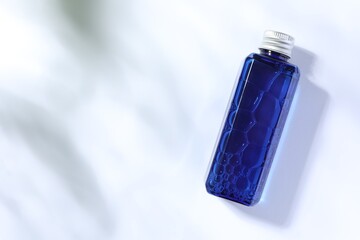 Bottle of cosmetic product on white background, top view. Space for text