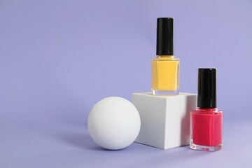 Stylish presentation of nail polishes on lilac background, space for text