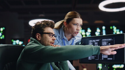 Programmers couple working together in dark room closeup. Analysts discussing