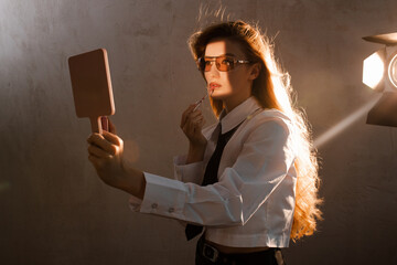 Stylish badass woman posing in studio with lighting setup 