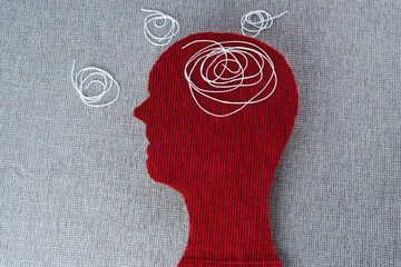 Human head red colored with a wound thread. Concept of chaotic thought process, confusion,...
