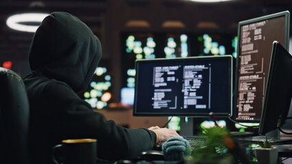 Anonymous hacker breaking cybersecurity dark room closeup. Cybercriminal reading