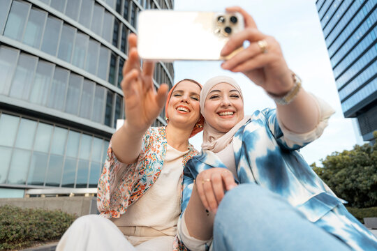 Portrait of happy muslim women friends making selfie together