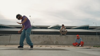 Group of skilled break dancer perform street dance with friend looking and cheering at him....