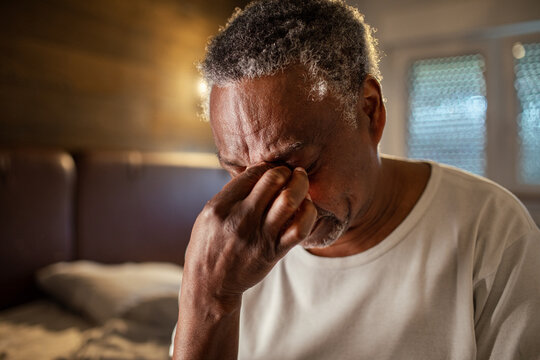 Senior man with a headache at home