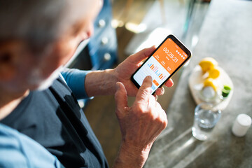Elderly man checking health app on smartphone for fitness tracking