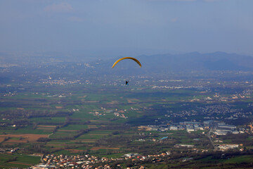 panorama of the valley with the houses and the paragliding with the sporty people